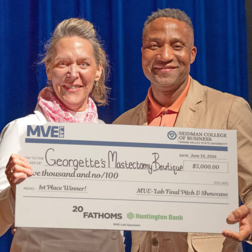 two people holding an oversized check on stage at the Traverse City Opera House